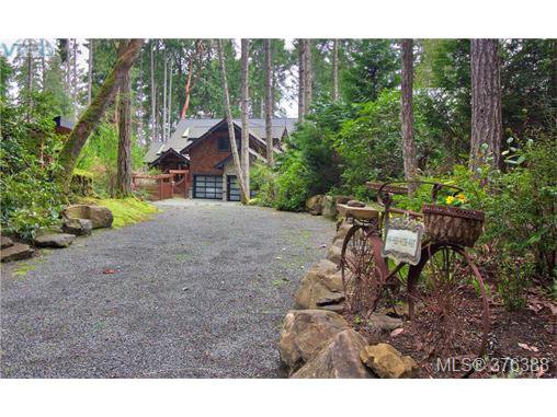 Charming stone flanked driveway leads to home.